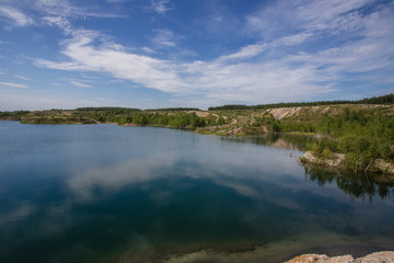 Flooded kaolin clay open pit quarry with blue water lake