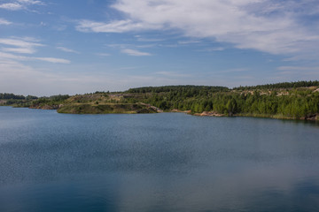Flooded kaolin clay open pit quarry with blue water lake