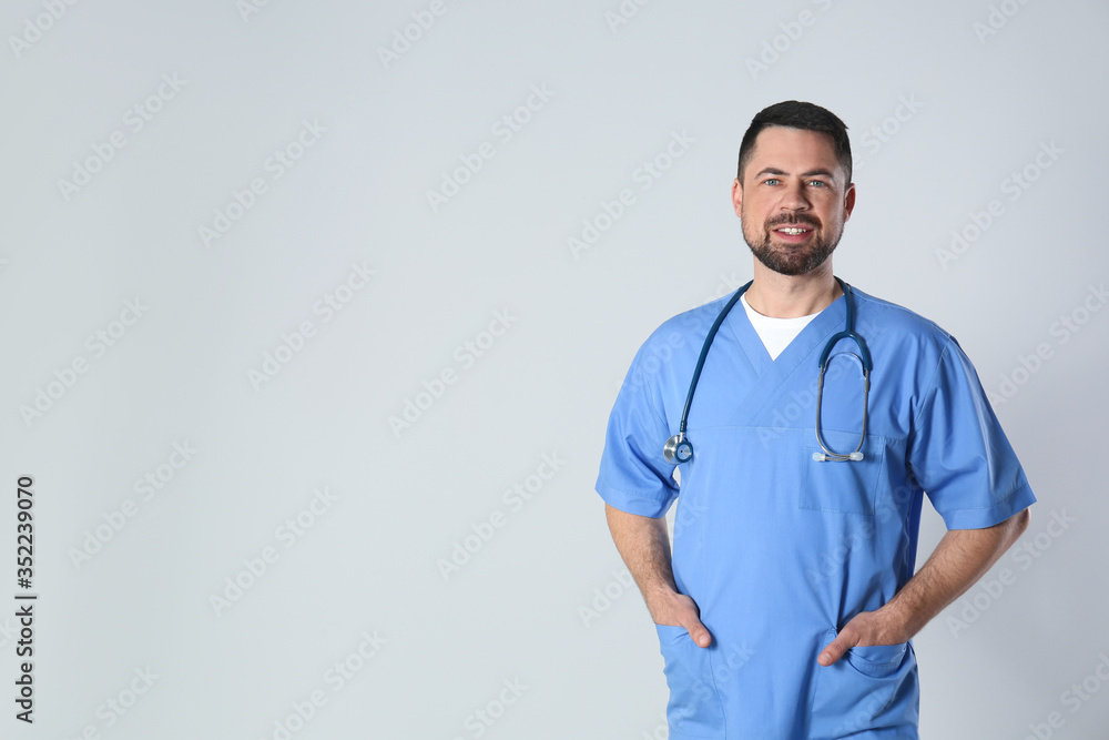 Poster Portrait of mature doctor against light background