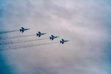 Military fighter aircraft flying in a simple construction against a background of white sky and clouds