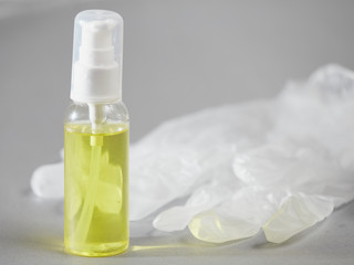 Tube with sanitizer and medical gloves on a gray background