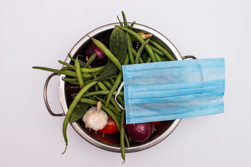 Mask placed on a vegetable basket on white background