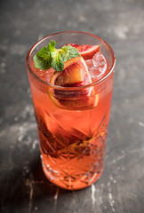 Red cocktail with blood oranges and thyme on the rustic background. Selective focus. Shallow depth of field.
