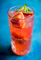 Red cocktail with blood oranges and thyme on the rustic background. Selective focus. Shallow depth of field.
