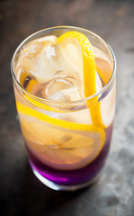 Gin based colorful cocktail with lemon and lavender liqueur on the rustic background. Selective focus. Shallow depth of field.