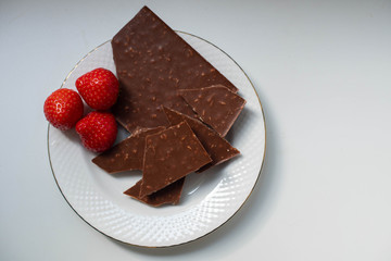 milk chocolate and strawberries on a saucer