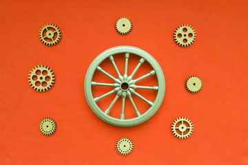 Wheel, wooden gears on a red background. Mechanism, movement.