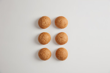 Horizontal shot of soft small round sesame burger buns for preparing delicious hambrugers or sandwiches. Nourishing crusty brioches isolated on white background. Fast food, unhealthy eating.