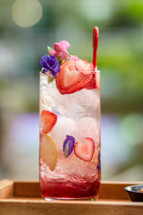 Ice with sweet water topped with Fresh pink lemonade with raspberries decorated with mint leaves, orange suitable for summer. Strawberry mojito cocktail. a green natural background. candy summer .
