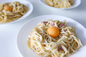 Carbonara pasta with egg yolk and bacon closeup background