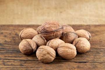 group of fresh raw walnuts on a grunge wooden background. rustic and detailed image.