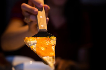 view of slice piece Salmon Sashimi pizza. Hand holding slice of pizza.