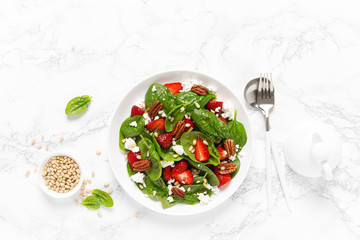 Fresh spinach salad with strawberry, pine and pecan nuts, goat cheese, maple syrup dressing