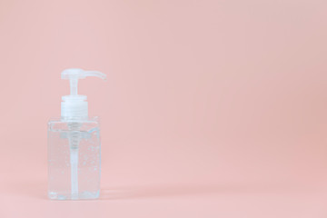 Hand sanitizer or alcohol gel for hand cleansing in clear or transparant bottle and the gel has air bubbles and at the end of the tube a gel was pouring out. Concept of object old roses backgrond.