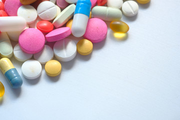 Close up of colorful pills on white background with copy space 