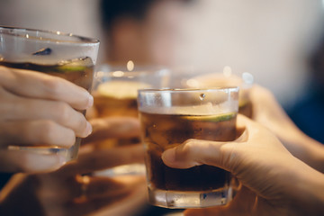 Friends drinking refreshment in the pizza restaurant. Man and Woman's hand holding coke cup with lemon slice and passion fruit juice.