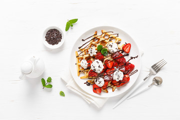 Belgian waffles with fresh strawberry, chocolate topping and whipped cream