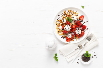 Belgian waffles with fresh strawberry, chocolate topping and whipped cream