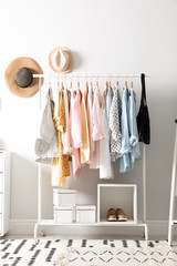 Rack with stylish women's clothes indoors. Interior design