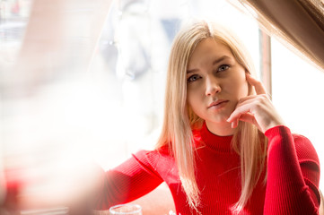 portrait of a girl in a red dress looking with blue eyes at the camera