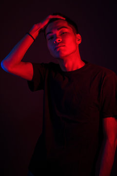 Stylish Guy Under Colored Lights, Standing In The Studio Under Red And Blue Light