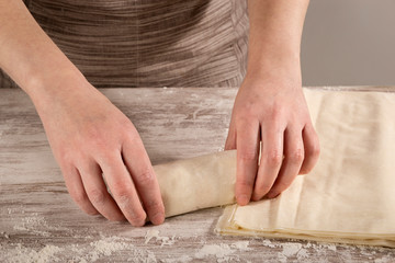 Woman making tuna rolls with phyllo dough for baking. Concept of healthy home-cooked food.