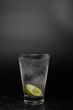 Soad water in glass with lime on black background. cool soda water and lime with copy space.