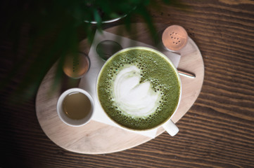 Obraz na płótnie Canvas green matcha latte stands on a wooden table