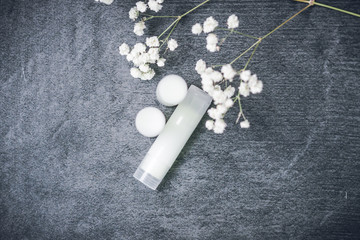 lip balm with flowers in a transparent tube with white contents. DIY lipstick made from natural eco-friendly ingredients. hand made on a gray background