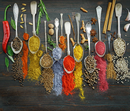 Spices on spoons with herbs on table top view. Variety of seasonings cuisine concept