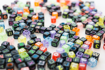 Colorful alphabets beads on white background, different colors with letters, concept image