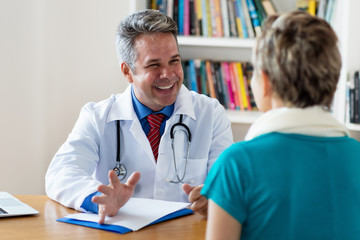 Lachender Arzt hat gute Nachrichten für Patientin