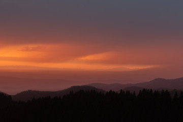 Sunrise landscape over carpathian mountain with orange sky in summer. Beautiful early morning mountain silhouette