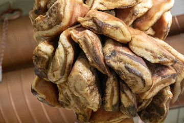 Air dried fatty meat processed and with pepper grain hanging on a ceiling at a butchery store. View from below on food background