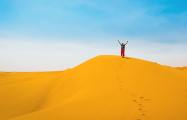 Sporty woman in Merzouga dunes of Sahara desert Morocco Africa. Travel and inspiration concept