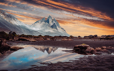 Impressive Colorful Seascape of Iceland. Wonderful picturesque Scene. Dramatic colorful sky glowing sunlit. Wonderful view of nature.  Best popular places near Stokksnes cape and Vestrahorn Mountain.