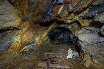 Underground abandoned mica ore mine tunnel with yellow dirt