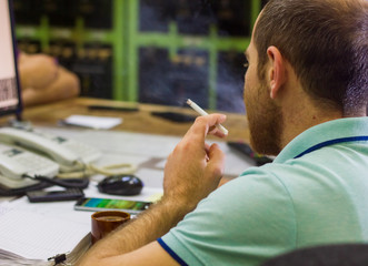 businessman smoking cigarette in his office, young man smoking cigarette