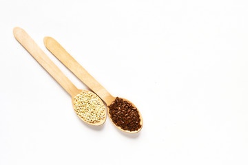 Flax seeds in a wooden spoon on a white background. View from above.