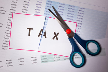 Cut taxes concept. Sciccors cut paper with word Tax