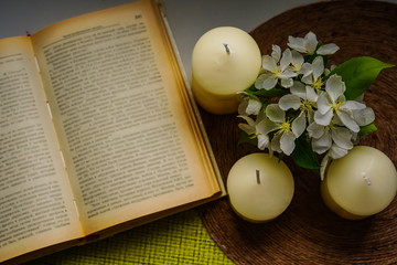Fototapeta na wymiar Book, candles, blooming apple tree on the window top view