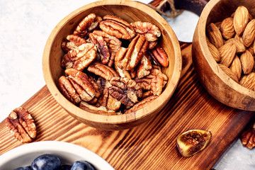 Peeled pecan nuts in the bowl on white background