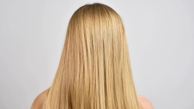 Haircare. Woman throws up hair. Beautiful healthy straight blonde hair.