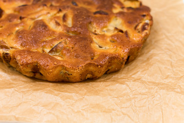 Homemade baked apple pie, in a plate, on a wooden table, ready to eat.