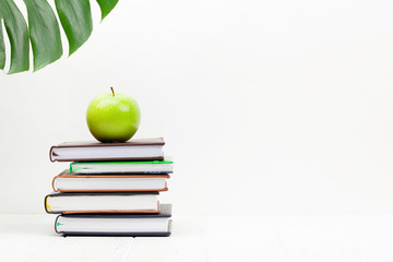Office desk workspace table with supplies and apple