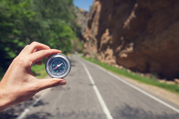 man hand compass in asphalt road