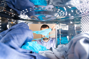 the man found someone else's thong underpants in the washing machine and looks at them. photo from inside the washing machine