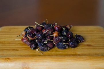 dried rosehip on a wooden board on the table, you can brew rosehip tea, vitamins, healthy