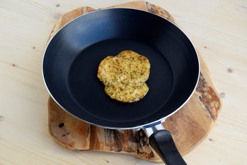 Chicken roasted fried in a pan. Chop is prepared with herbs and spices. Fresh hot roasted meat. Closeup black and wooden background.