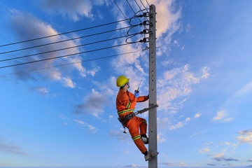 Electricians are climbing on electric poles to install and repair power lines.electricians work...